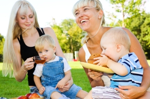 Happy mothers and their babies eating in the outdoors